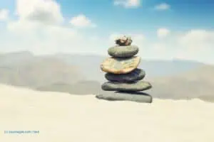 Balanced stones on a pebble beach during sunset.
